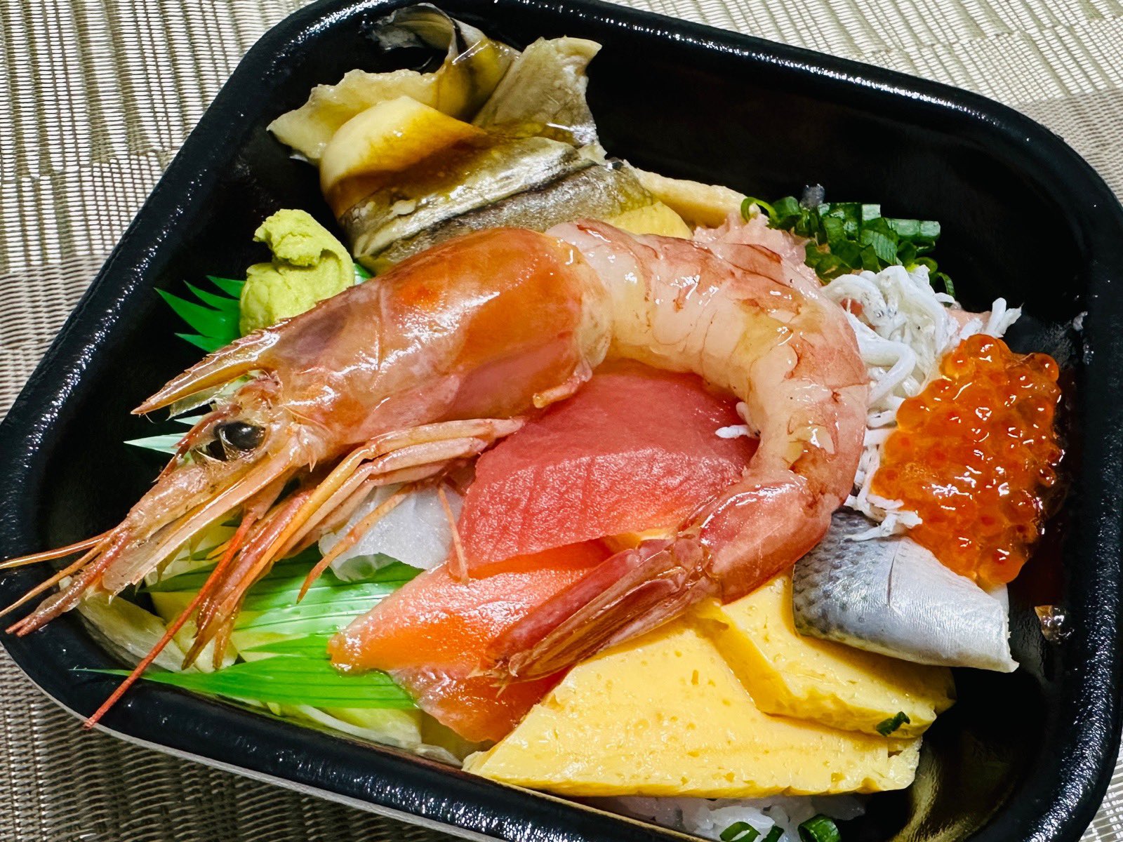 汐音丼丸の汐音丼 (しおのねどん)。Google店舗情報のメニューによると「店舗オリジナル商品!11種類のネタが入っており、当店一押し商品です。ぜひ一度お試しください。(穴子、数の子、タイ、サーモン、厚焼き玉子、小肌、ネギトロ、シラス、イクラ、マグロ、有頭生エビ)」とのこと。 汐音丼丸の汐音丼 (しおのねどん)。Google店舗情報のメニューによると「店舗オリジナル商品!11種類のネタが入っており、当店一押し商品です。ぜひ一度お試しください。(穴子、数の子、タイ、サーモン、厚焼き玉子、小肌、ネギトロ、シラス、イクラ、マグロ、有頭生エビ)」とのこと。