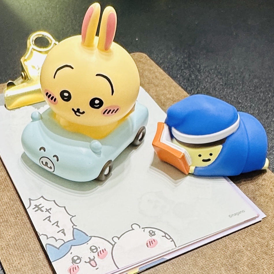 A rabbit is driving a car and a pudding is lying down and reading a book. A rabbit is driving a car and a pudding is lying down and reading a book.
