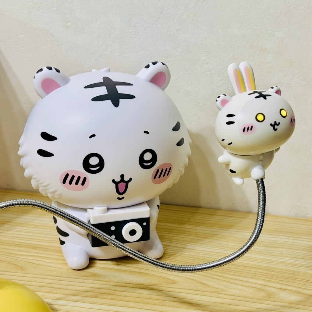 Grokへの指示「ハチワレをかわいいホワイトタイガーの赤ちゃんにして、カメラなど持ち物はそのままで。うさぎを目が光っているホワイトタイガーの赤ちゃんにして。」 